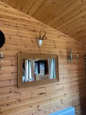 a mirror on the wall of a log cabin at Ben Lomond Lodge in Rowardennan