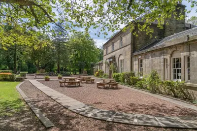 a courtyard with picnic tables and a building at Bankton Rooms & Lodges in Livingston