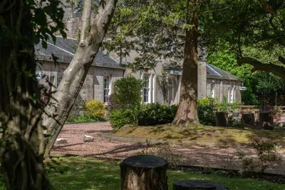 a house with two trees in front of it at Bankton Rooms & Lodges in Livingston