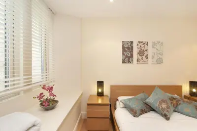 a white bedroom with a bed and a window at Edinburgh Church Apartments in Edinburgh