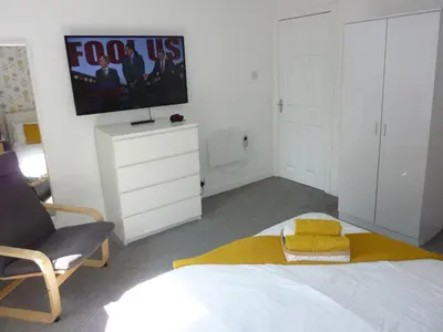 a bedroom with a bed and a tv on the wall at Paisley Central Apartment #4 in Paisley