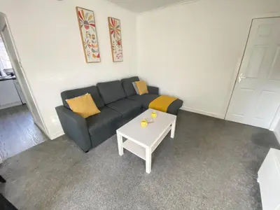 a living room with a couch and a table at Paisley Central Apartment #4 in Paisley