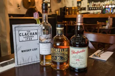 two bottles of alcohol sitting on a table at The Clachan Inn in Drymen