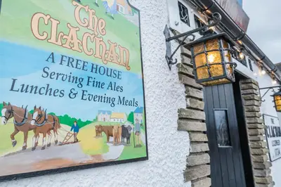 a sign on the side of a free house serving true aids lunches and exciting at The Clachan Inn in Drymen