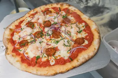 a pizza with shrimp and onions on a table at The Clachan Inn in Drymen