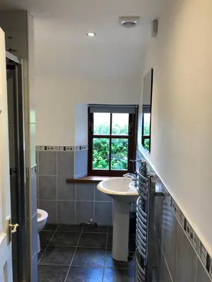 a bathroom with a sink and a toilet and a window at The Coach House in Skelmorlie