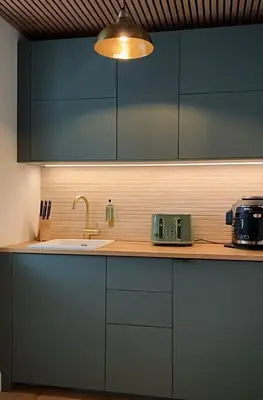 a kitchen with blue cabinets and a sink and a toaster at Lochside Guest House in Arrochar