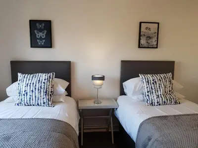two beds sitting next to each other in a room at Carnegie Place in East Kilbride