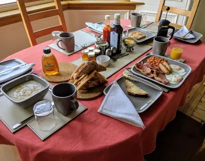 a table with breakfast food on a red table cloth at Falcon Crest Guest House in Edinburgh