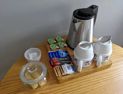 a wooden table with a coffee maker and food on it at Falcon Crest Guest House in Edinburgh