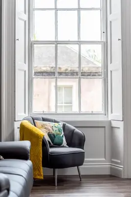a living room with a couch and a large window at Spacious newly refurbished central apt in Edinburgh