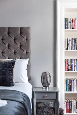 a bedroom with a bed and a book shelf with books at Spacious newly refurbished central apt in Edinburgh
