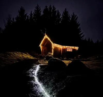 a small cabin with lights on it at night at The Nest Glamping Pod in Dalmally