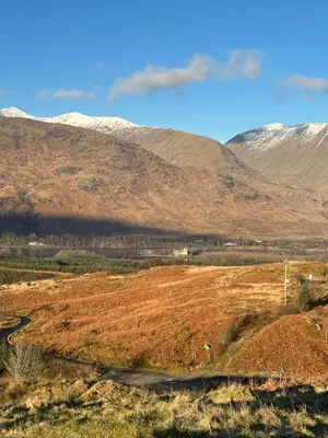 a view of a field with mountains in the background at The Nest Glamping Pod in Dalmally