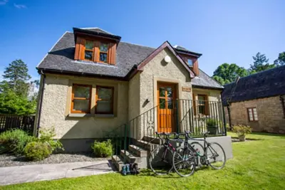 a house with bikes parked outside of it at Bonnie Banks Cottage in Balloch
