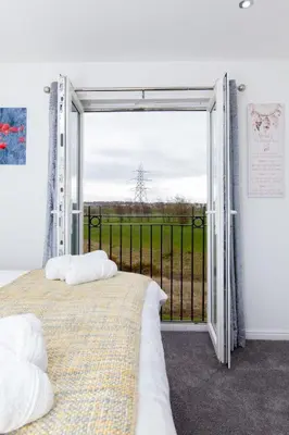 a bedroom with a bed and a large window at Super Prime Park View Duloch by TBA in Dunfermline