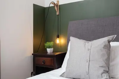 a bed with a pillow and a plant on a night stand at Turnberry Serviced Apartments in Turnberry
