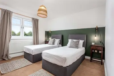 two beds in a room with green walls and windows at Turnberry Serviced Apartments in Turnberry