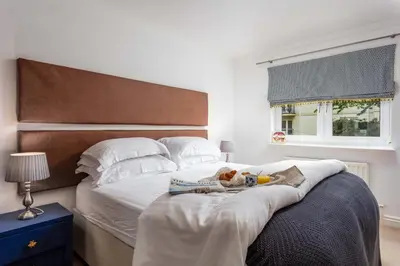 a bed with a book and a teddy bear on it at Turnberry Serviced Apartments in Turnberry