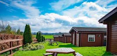 a cabin yard with a picnic table and a bench at Ingliston Country Club Hotel in Bishopton