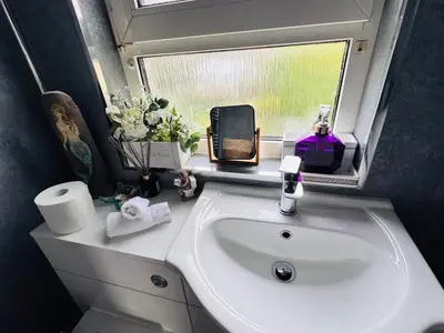a bathroom with a sink and a window at Park Road Holiday Home - Spacious 3 bedroom house with garden near Edinburgh in Rosyth