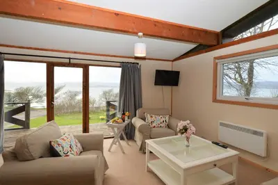 a living room with two couches and a table at Clamshell Lodge in Otter Ferry
