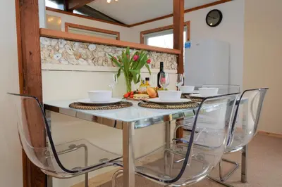 a dining room table with chairs and wine bottles at Clamshell Lodge in Otter Ferry