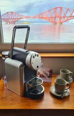 a coffee maker sitting on a table next to cups at Orocco Pier in Queensferry