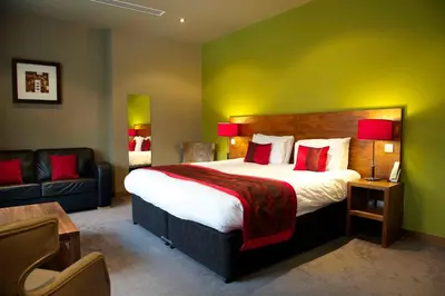 a hotel room with a large bed and a couch at Orocco Pier in Queensferry