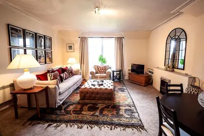 a living room with a couch and a table at Butler's Apartment. Flat 5, Dalmore House, Helensburgh, Scotland G84 8JP in Helensburgh