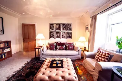 a living room with a couch and a table at Butler's Apartment. Flat 5, Dalmore House, Helensburgh, Scotland G84 8JP in Helensburgh