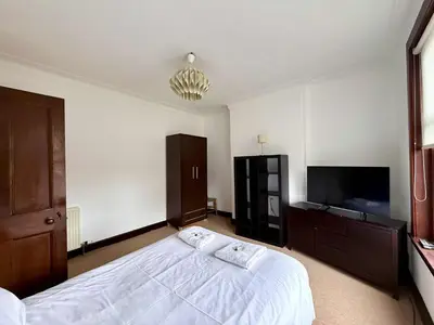a bedroom with a large bed and a flat screen tv at The Orchard Hotel in Falkirk