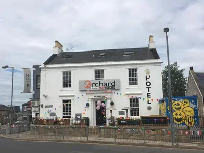 a white building on the corner of a street at The Orchard Hotel in Falkirk