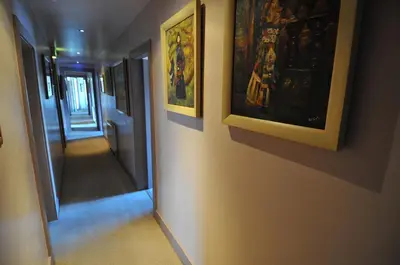a hallway with paintings on the wall and a mirror at The Orchard Hotel in Falkirk