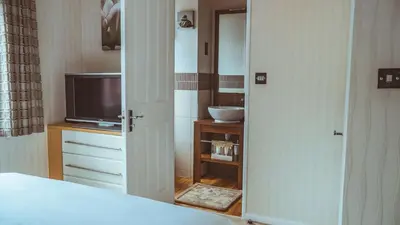 a bedroom with a bed and a television at Bonnie Banks Lodge Ardlui in Ardlui
