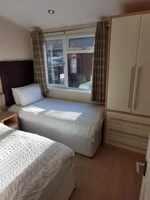 a bedroom with two beds and a window at Bonnie Banks Lodge Ardlui in Ardlui
