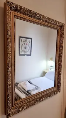 a mirror hanging on a wall next to a bed at The Guards Hotel in Edinburgh