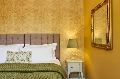 a bedroom with a bed and a mirror on the wall at Merlindale in Crieff