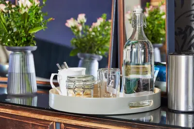a bottle on a tray on a table with glasses at Merlindale in Crieff