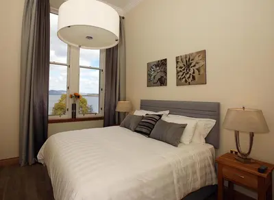 a bedroom with a white bed with a window at 4 Lomond Castle in Balloch