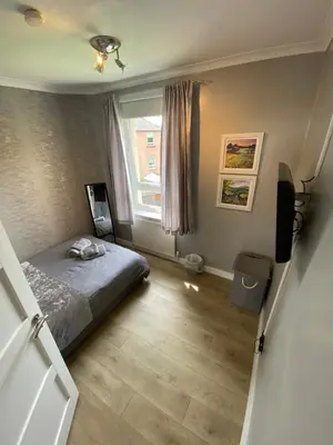 a small bedroom with a bed and a window at Modern Quiet City Center Airport 2 Bedroom Apartment in Edinburgh