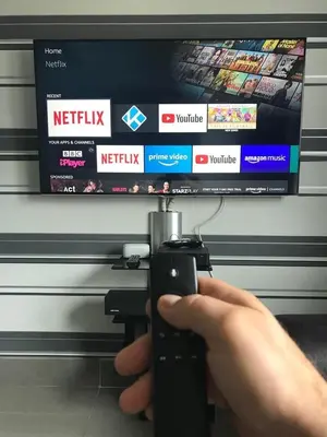 a person holding a remote control in front of a television at Modern Quiet City Center Airport 2 Bedroom Apartment in Edinburgh