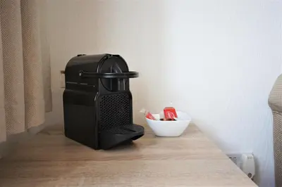 a black coffee maker sitting on top of a table at Bright and Cosy West End Apartment in Glasgow