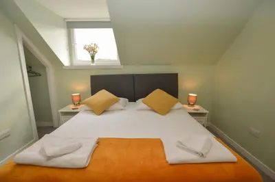 a bedroom with a large white bed with two lamps at Fairhaven, Oban Town Centre in Oban