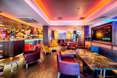 a restaurant with colorful chairs and a bar at Leonardo Hotel Edinburgh Haymarket in Edinburgh
