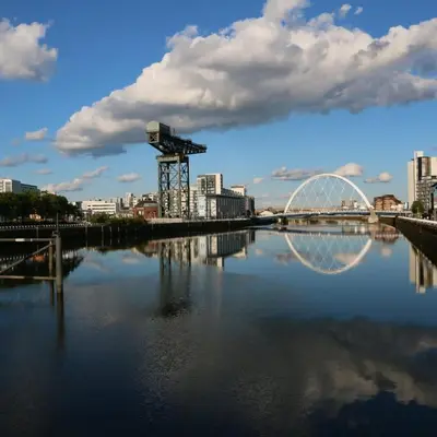 a bridge over a river with a city in the background at Beautiful 2 Bed Apartment Rose St in Glasgow