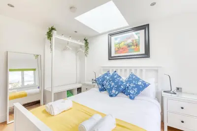 a bedroom with a white bed with blue pillows at Central Bright 3 Bed Flat with Pool & Parking in Edinburgh