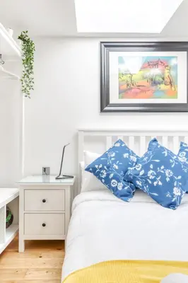 a bedroom with a white bed with blue pillows at Central Bright 3 Bed Flat with Pool & Parking in Edinburgh