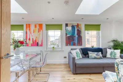 a living room with a couch and a glass table at Central Bright 3 Bed Flat with Pool & Parking in Edinburgh