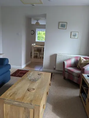 a living room with a wooden coffee table and a couch at Boreland Farm in Dunscore